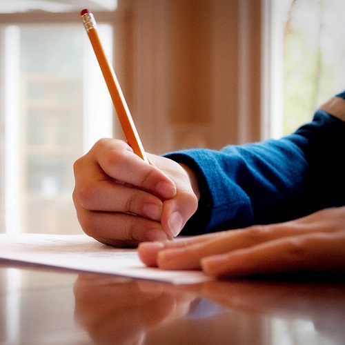 Little boy writing with pencil